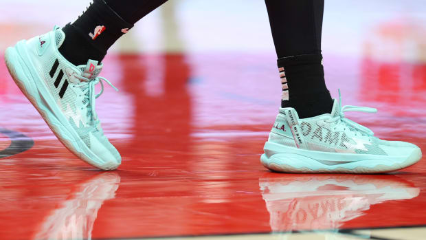 View of teal and black adidas shoes.
